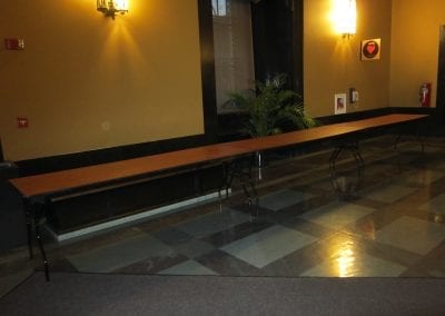 A long table in Rackham's lobby with checkered flooring and wall sconces.