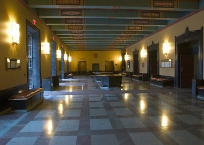 Spacious lobby with tiled floor, benches, and decorative ceiling in the Rackham Building.