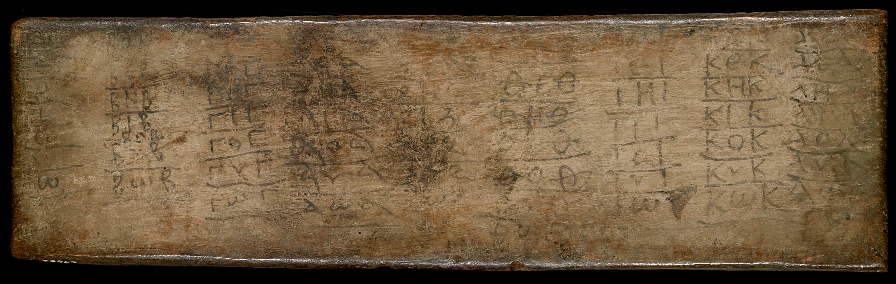 Greek syllables on a wooden board.