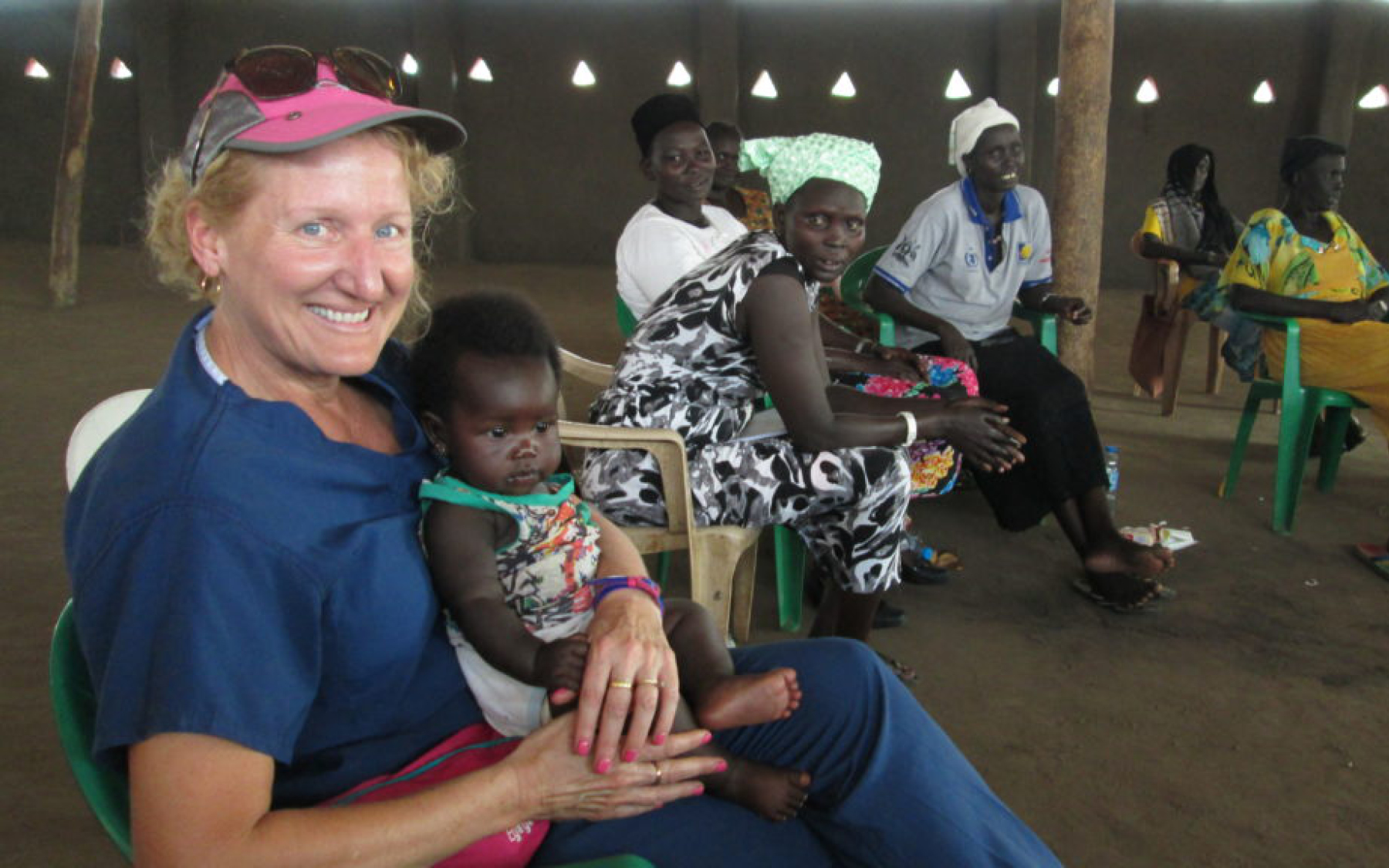 Ruth Zielinski holds a baby whose mother is taking Zielinski’s class on family and child health in a Ugandan refugee camp.