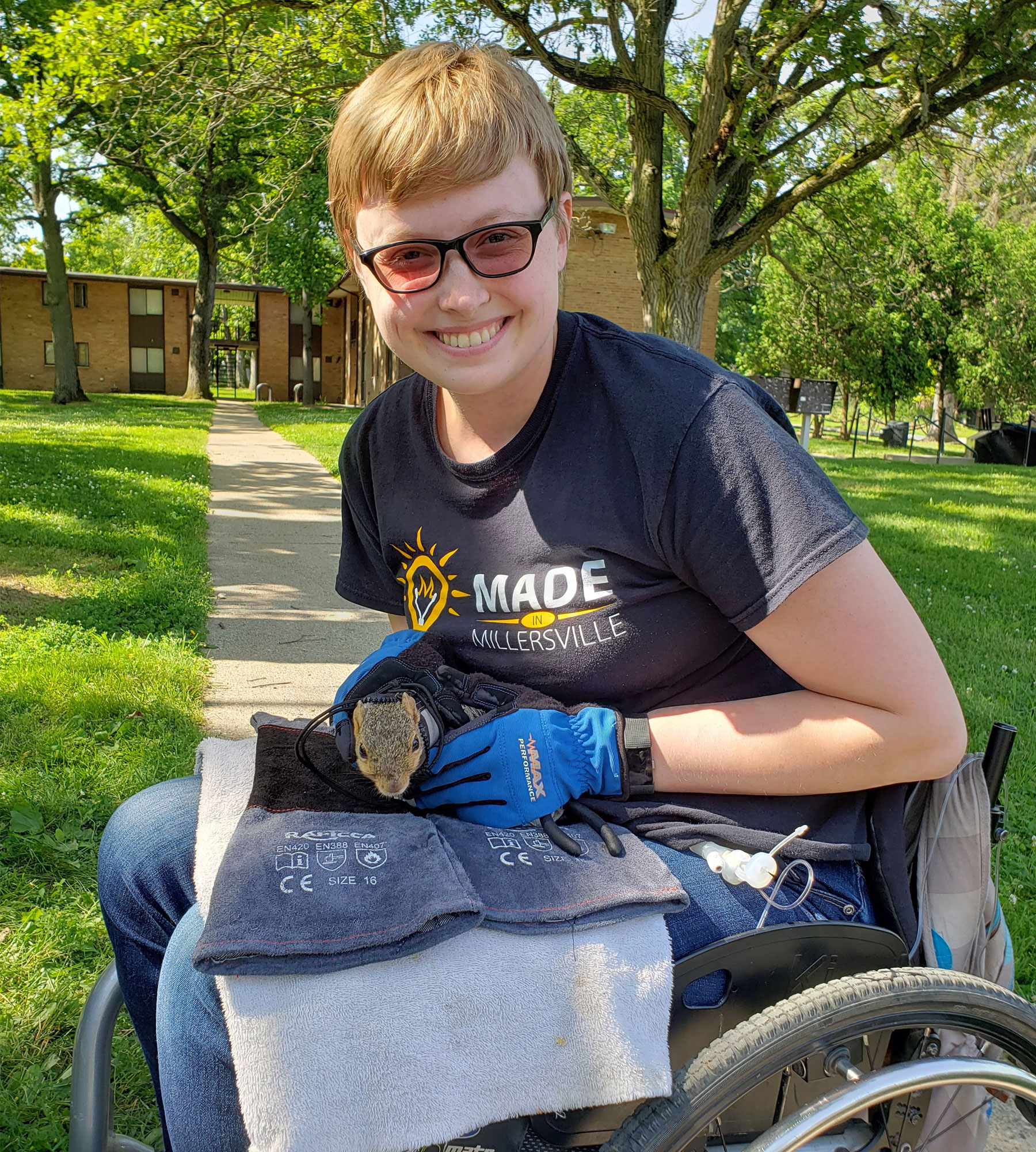 Amy-Charlotte Devitz sits in her motorized wheelchair and holds a squirrel during her on-campus research.