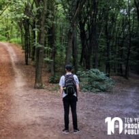 A person with a backpack stands at a fork in a forest trail, facing two diverging paths; "Ten Years Program in Public Scholarship" text is in the corner.