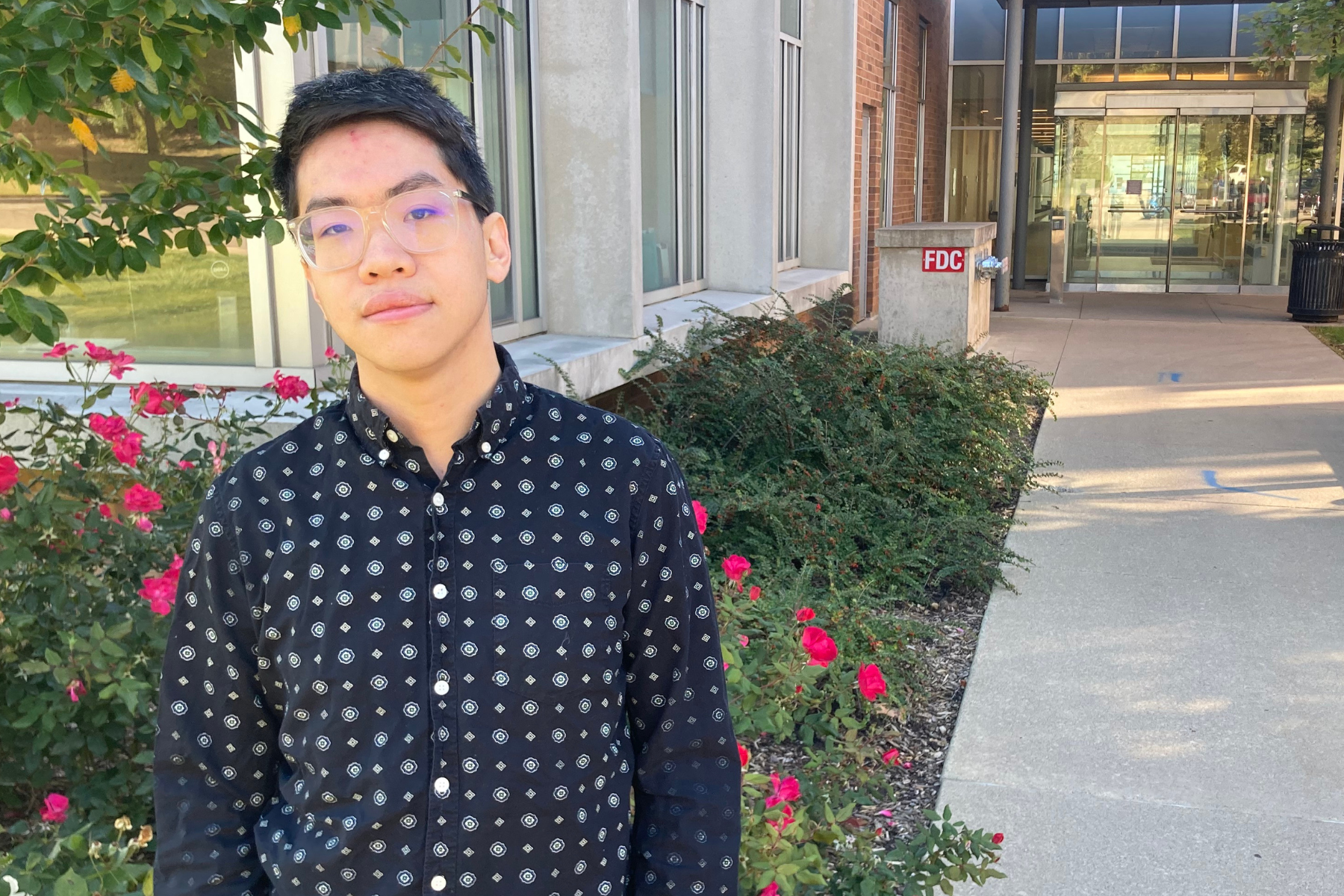 Trenton Chang stands outside of the Bob and Betty Beyster Building.