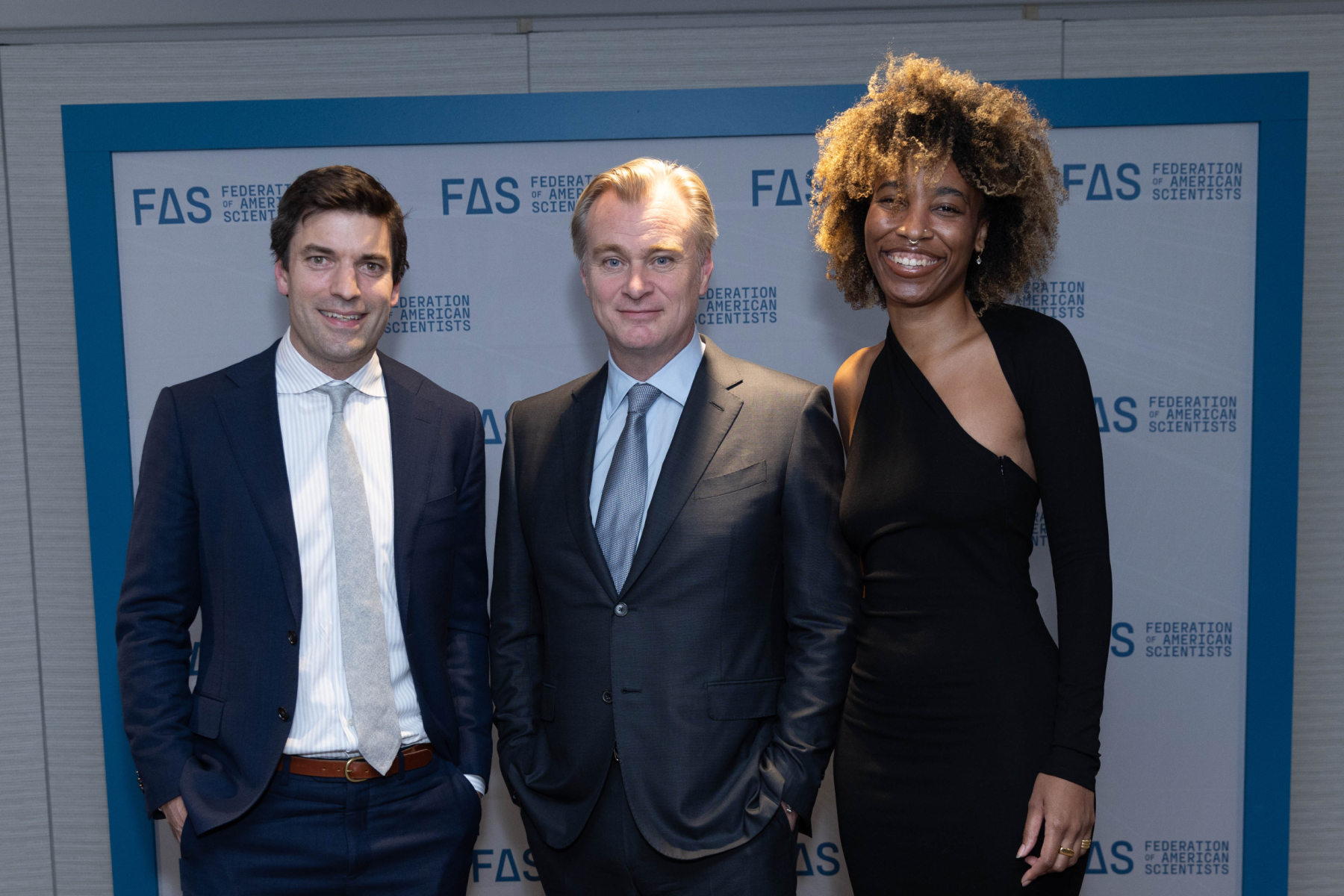 Three people posing for a photo at an event.