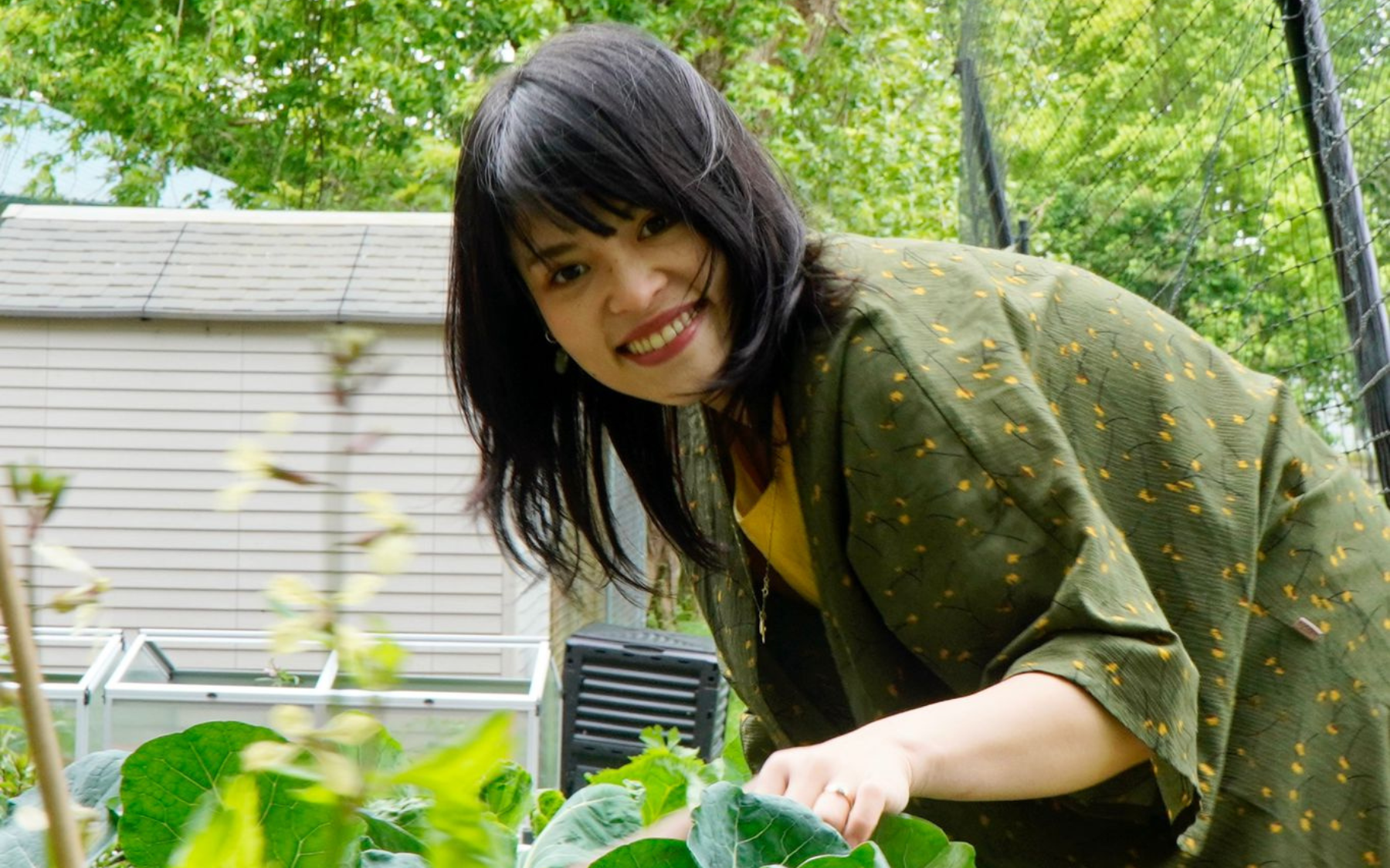 Khánh Linh Trinh tends to her garden, smiling.