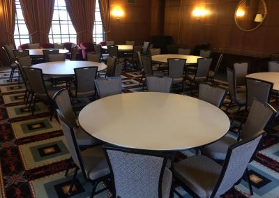 A conference room in the Rackham Building with circular tables and chairs arranged around each table, ready for a meeting or event.