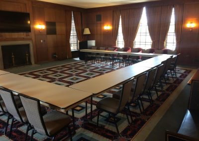 Conference room in the Rackham Building with a large table, chairs, and a fireplace.