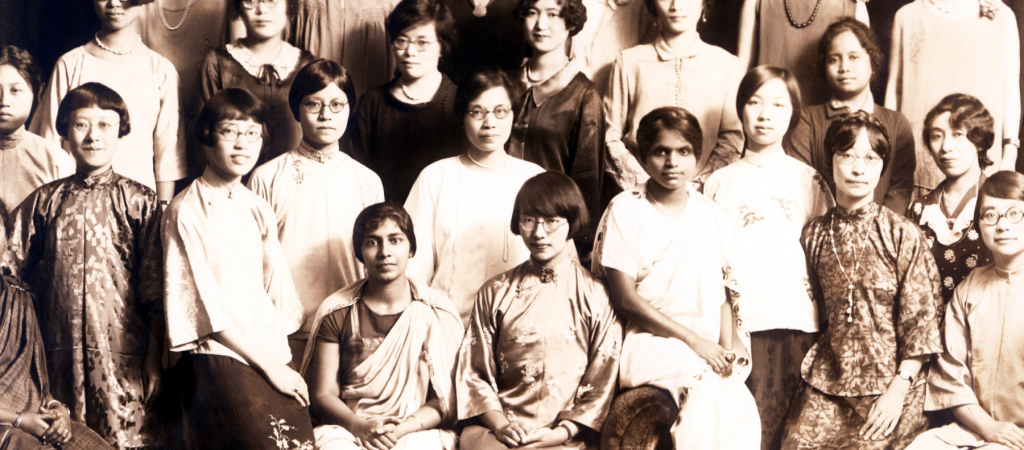 A group of women in traditional and contemporary clothing pose for a formal portrait.