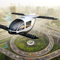 Futuristic flying car with multiple rotors hovers above a cityscape with highways and high-rise buildings.