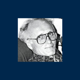 Black and white photo of an older man with glasses, light hair, and a patterned shirt, smiling slightly at the camera.
