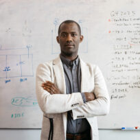 William Tarpeh standing in front of a white board.