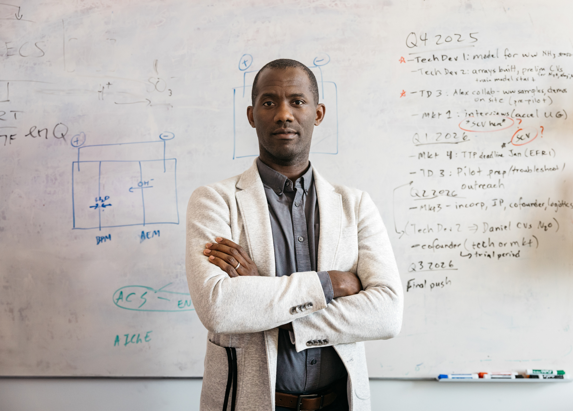 William Tarpeh standing in front of a white board.