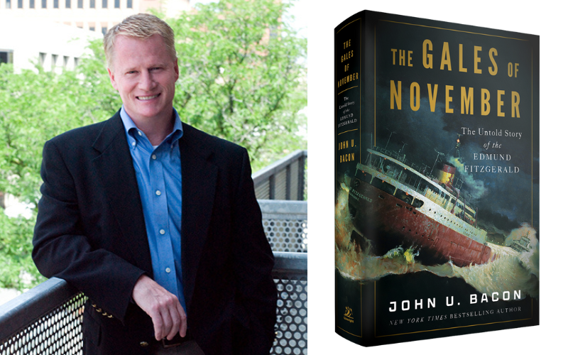 John U. Bacon in a suit stands on a balcony next to the cover of his book titled "The Gales of November."