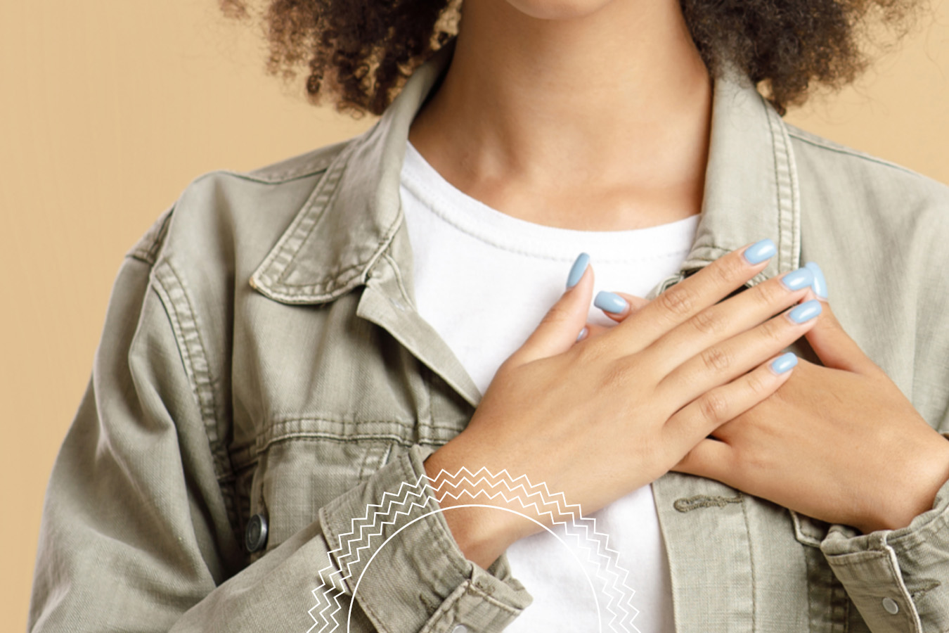Person in a light denim jacket and white shirt with hands crossed over their chest, showing blue painted nails, against a beige background.