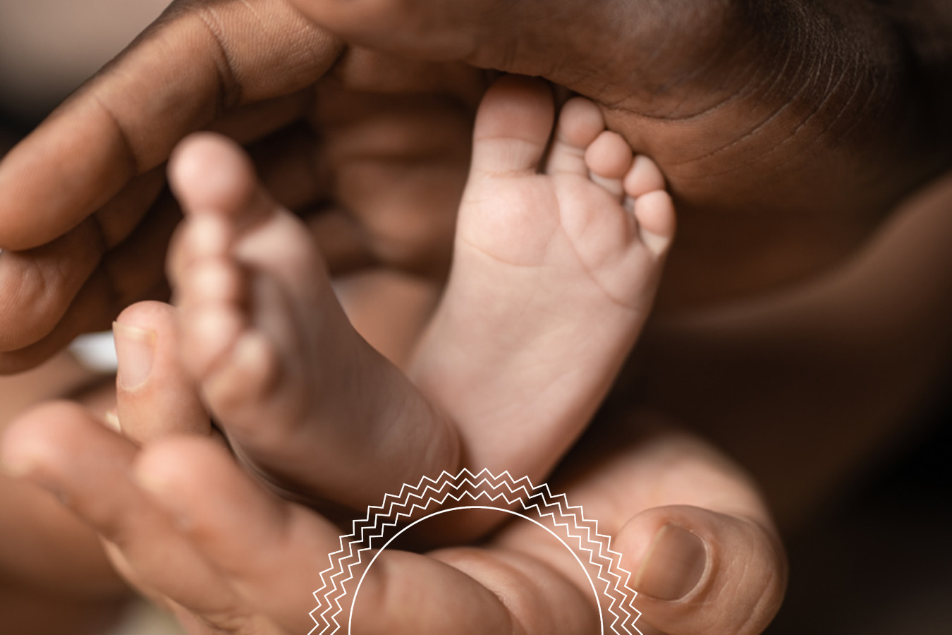 Close-up of adult hands gently cradling a baby’s feet, with soft focus and warm lighting.