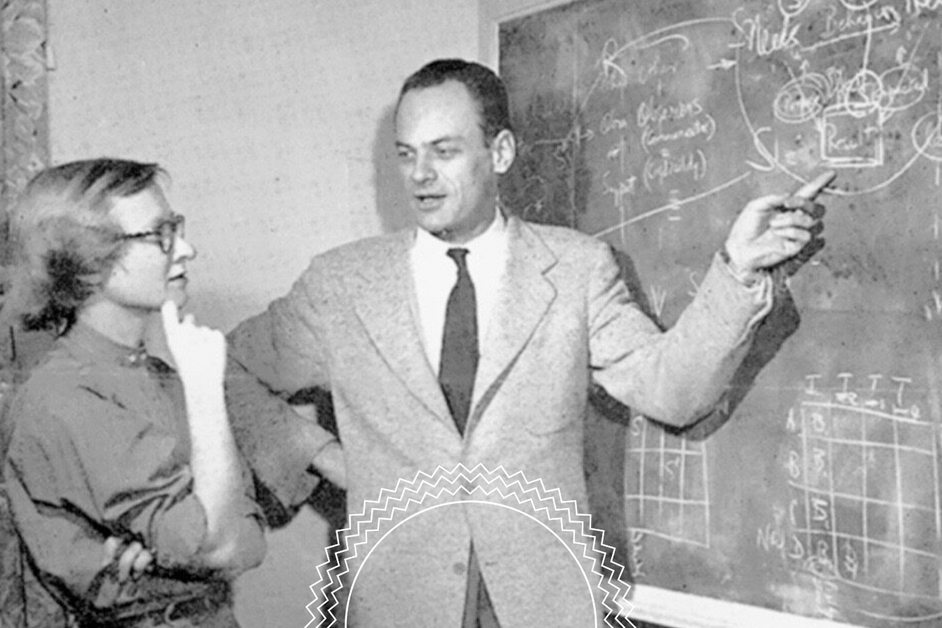 A man in a suit explains diagrams on a chalkboard to a woman who is listening with her hand on her chin.