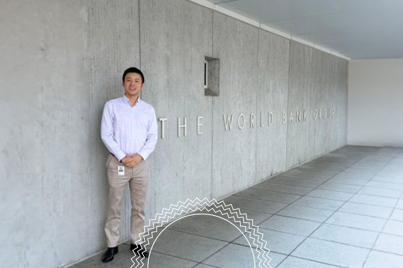 A person stands next to a concrete wall with “THE WORLD BANK GROUP” written on it, in an outdoor walkway area.