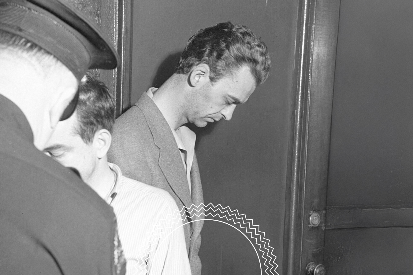 Two men stand facing downward near a closed door, with a uniformed officer partially visible on the left side of the image.