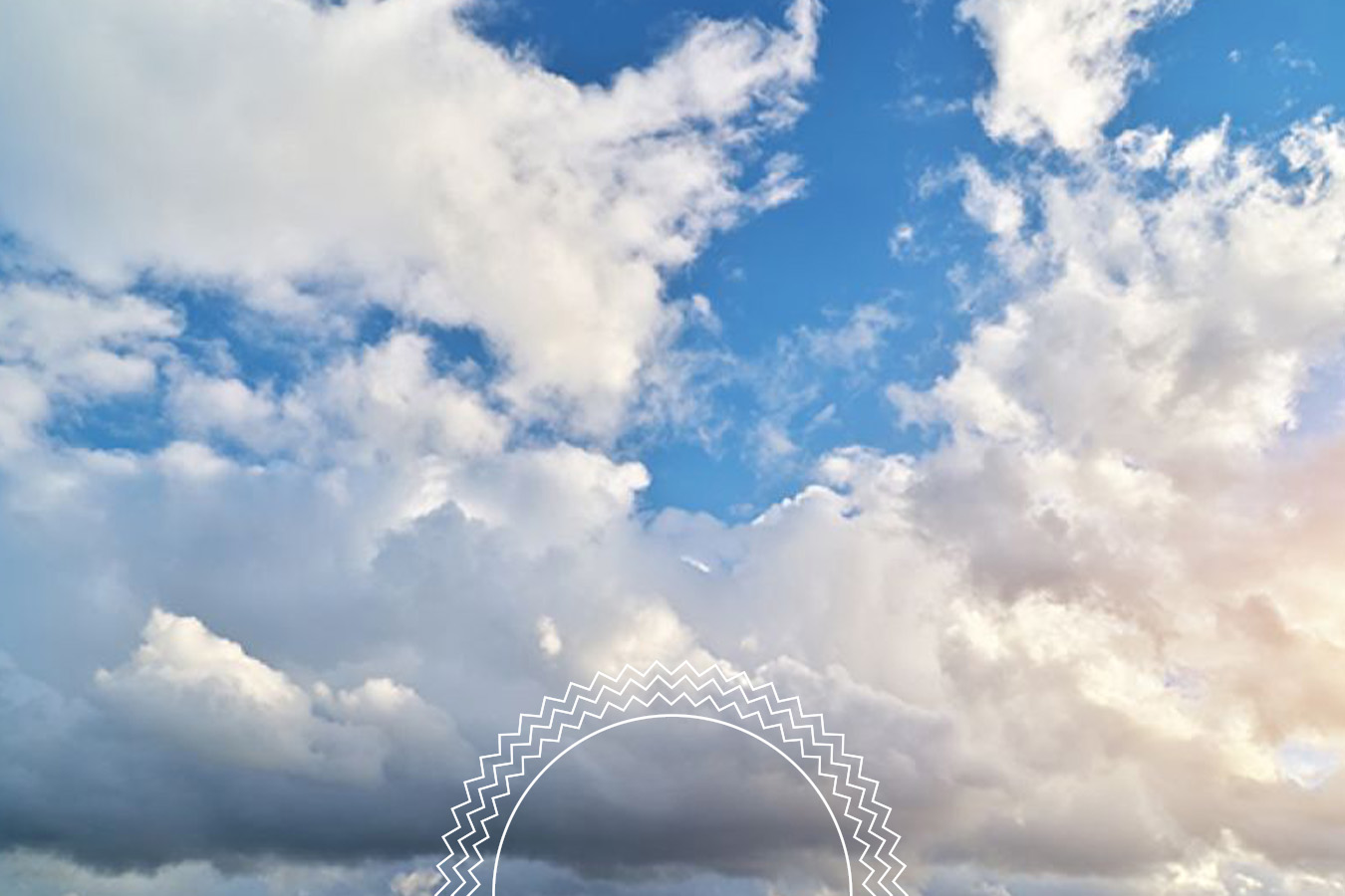 Blue sky with scattered white clouds; sunlight is faintly visible on the right side. A circular transparent watermark with a zigzag pattern appears near the bottom center of the image.
