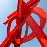 A red metal sculpture against a blue sky