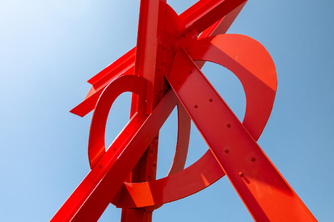 A red metal sculpture against a blue sky