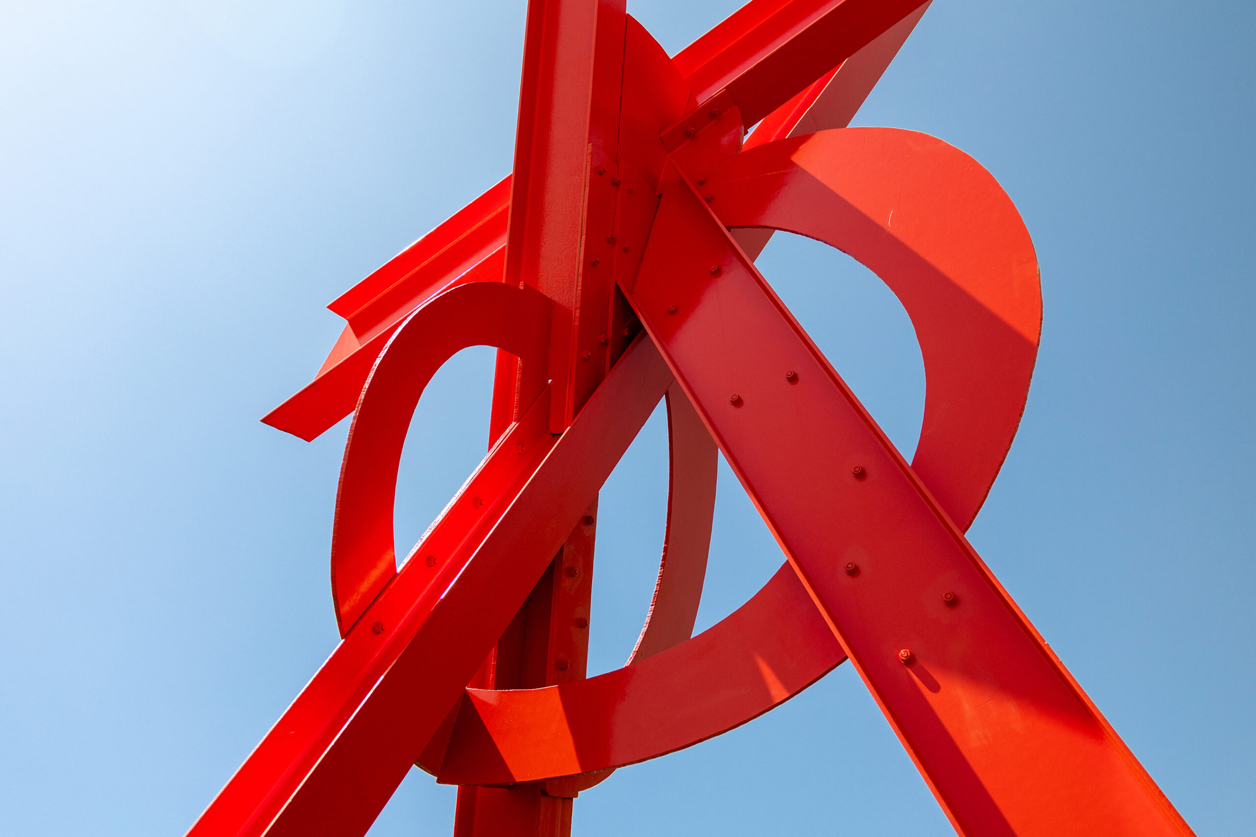 A red metal sculpture against a blue sky