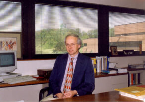 Professor Emeritus Toby J. Teorey at his desk, wearing a jacket and tie.